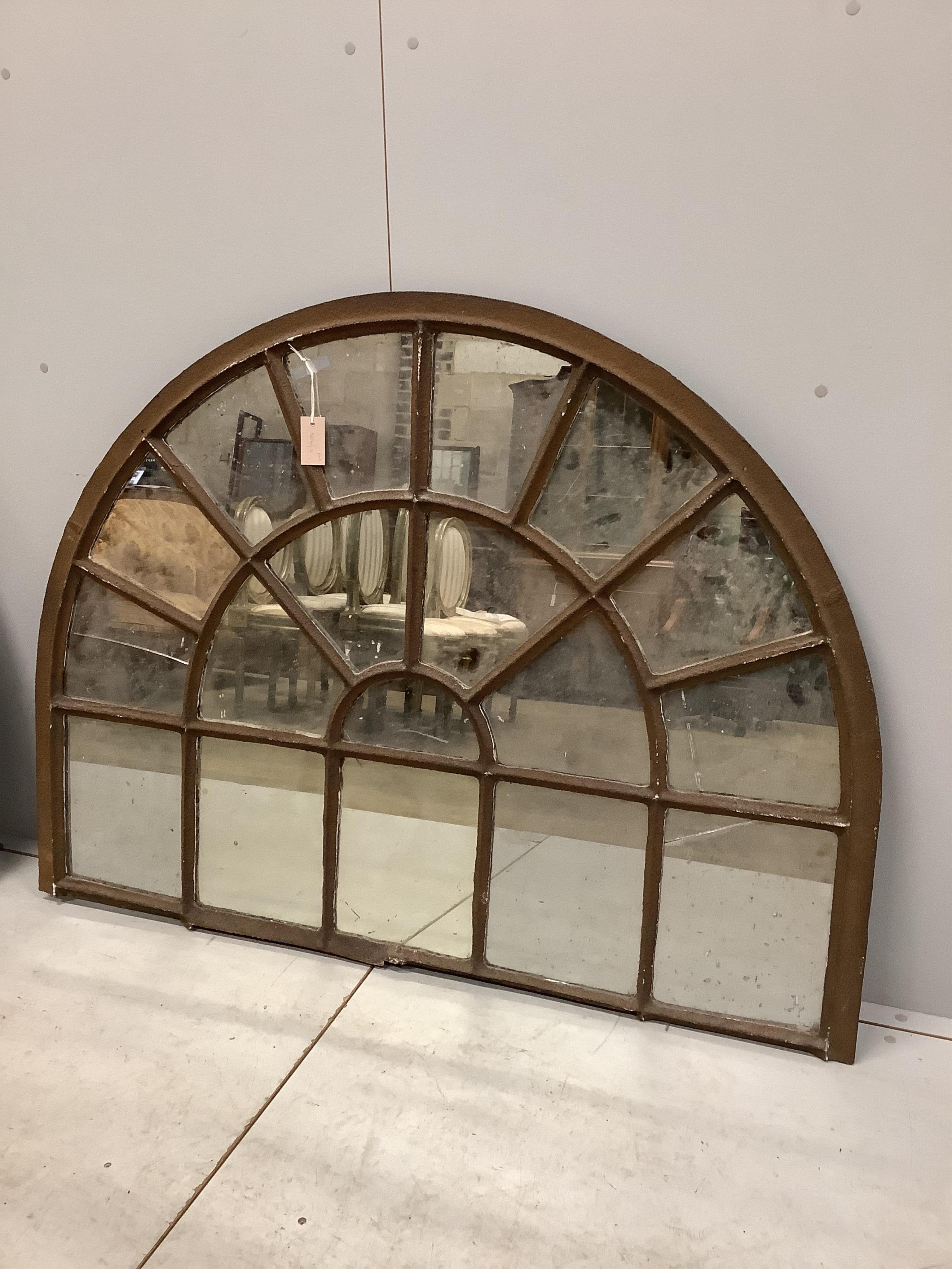 A pair of architectural cast iron window panel wall mirrors of domed form, width 136cm, height 102cm. Condition - fair, four panes cracked.